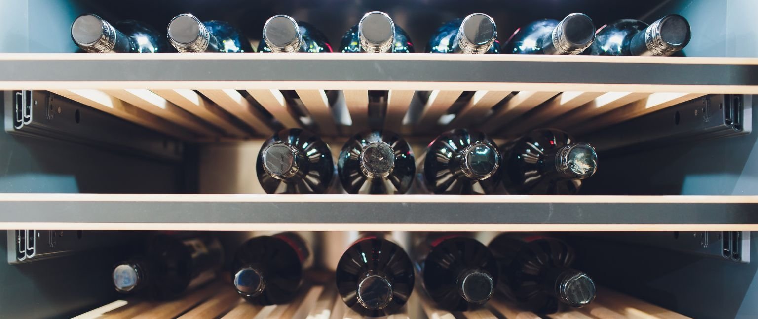 Εσωτερικό συντηρητή κρασιών με πολλαπλά ράφια και αποθηκευμένα μπουκάλια κρασιού