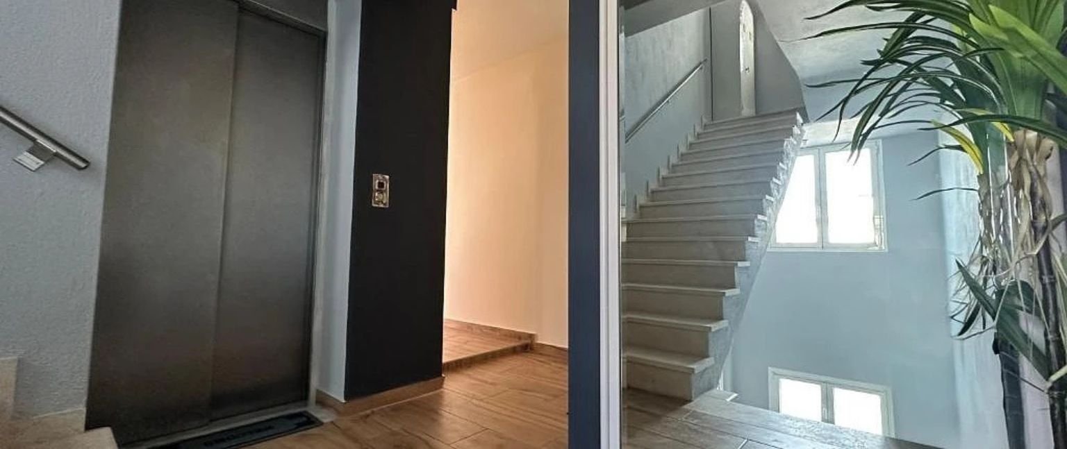 Είσοδος πολυκατοικίας με ανελκυστήρα και κλιμακοστάσιο σε σύγχρονο κτίριο