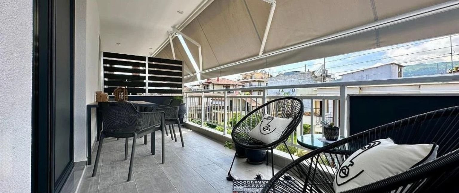 Μπαλκόνι διαμερίσματος με καθιστικό εξωτερικού χώρου και θέα πόλης
